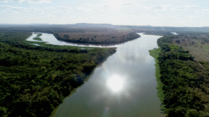 Imagem aérea do encontro das águas dos rios das Velhas e São Francisco, na Barra do Guaicuí (MG), com reflexo do sol no rio das Velhas