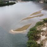 Imagem mostra água do Rio Doce tomada por lama e assoreamento